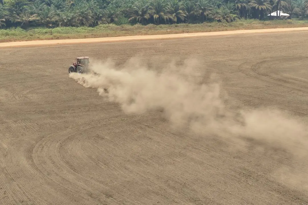 A tractor prepares an expansive field